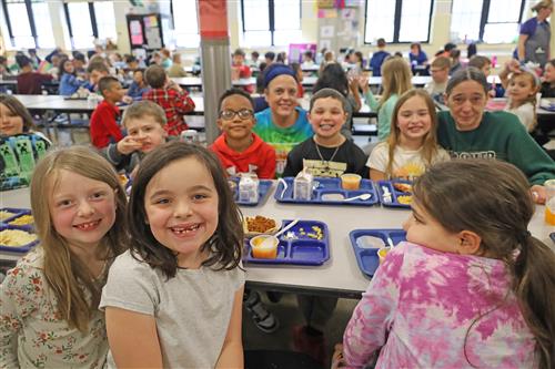 kids smiling at school lunch table